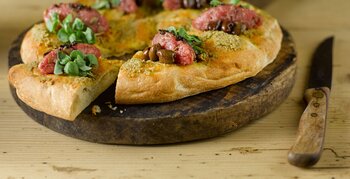 „Pizza Boden“ mit Fassona Rindertatar, Oliven und Salzkapern